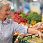 senior-woman-at-the-farmers-market-holding-a-shopping-bag-looking-at-fruits-and-vegetables-price-increase-and-inflation