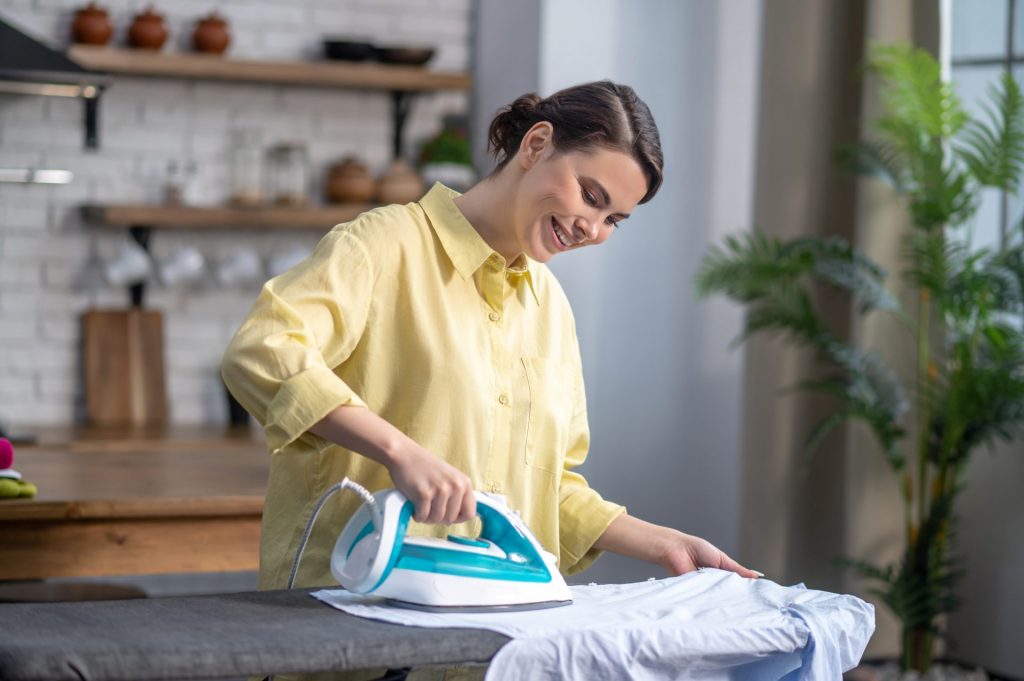 smiling-beautiful-housewife-ironing-the-wrinkled-shirt
